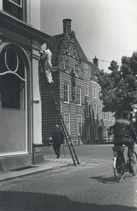 502625 Afbeelding van een schilder op een ladder aan het werk bij het pand Achter de Dom 13 te Utrecht, gezien vanaf de ...